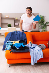 Young man student preparing for trip at home