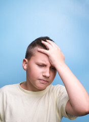 Fototapeta premium boy covering head with hand being tired, headache, showing true emotion.
