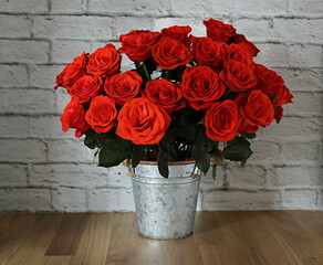 Still life with a bouquet of red roses in a vase on a white background.
