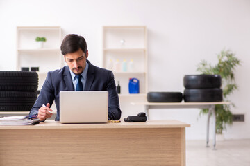 Young man selling tires in the office