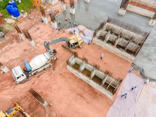 Aerial view big excavator with concrete truck on construction and worker pouring a wet concret at construction site, Concrete construction