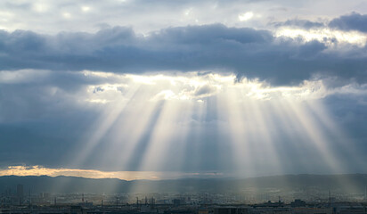 Dramatic crepuscular rays at sunrise in Osaka, Japan