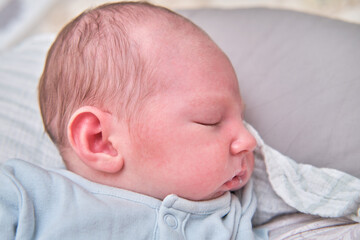 Portrait of a baby boy after feeding with milk on his lips, well-fed child face