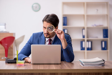 Young male employee sitting at workplace