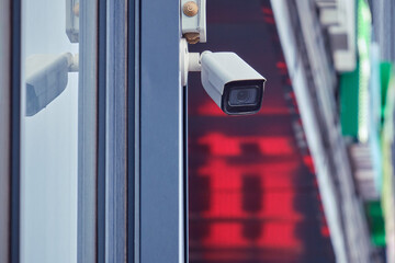 Video surveillance camera on the store building, monitoring the security of the entrance to the...
