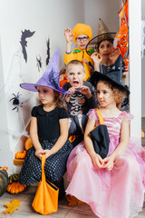Halloween holiday party for children. Kids in costumes on staircase