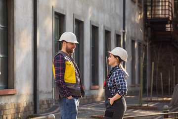 Woman and man, factory employees chatting during lunch break