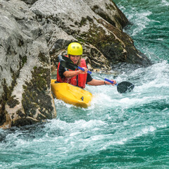 Junges M&auml;dchen steuert gekonnt ihr Boot durch die Stromschnellen auf der Soca in einer felsigen Schlucht