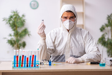Young male chemist working at the lab during pandemic