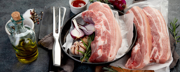 Raw pork belly on dark gray background. Organic gourmet food concept.