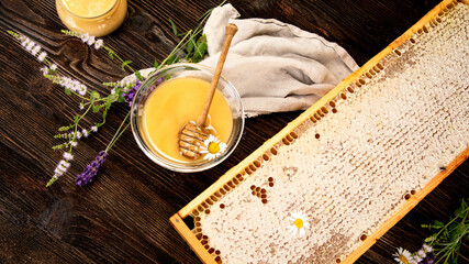 Honey in a jar and a honeycomb on wooden background.