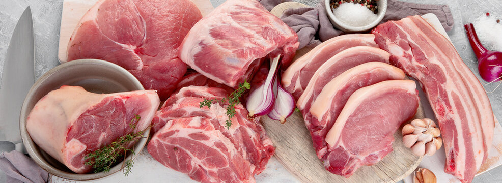 Assortment of raw pork meat on light grey background. Organic gourmet food concept.