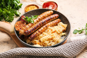 Frying pan with tasty sauerkraut, grilled sausages and sauces on grunge background, closeup