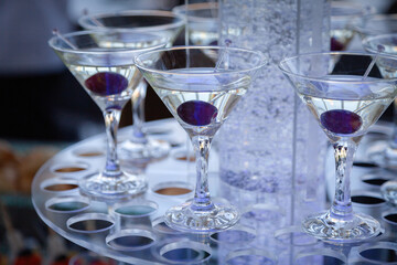 many glasses of martini with black olives at the party