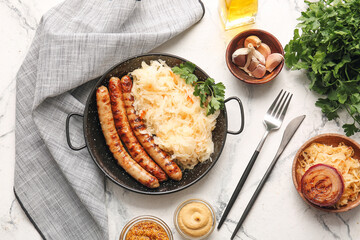 Frying pan with tasty sauerkraut and grilled sausages on light background