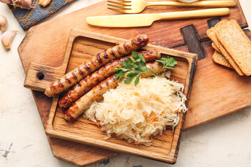 Board with tasty grilled sausages and sauerkraut on light background, closeup