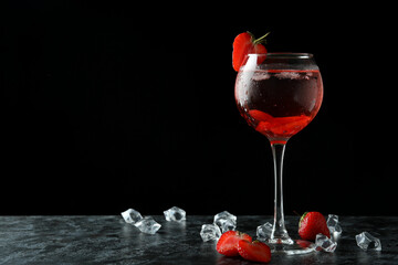 Glass of fresh strawberry cocktail on black smokey  table