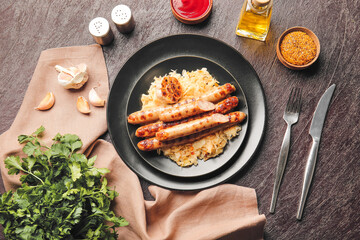 Plate with tasty grilled sausages and sauerkraut on dark background