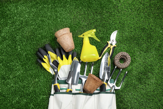 Flat lay composition with gardening tools on green grass