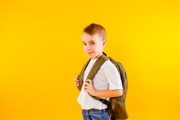 the little pupil wearing style clothes stands with folded arms
