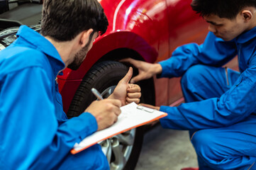 Close up thumbs up hand sign of professional look technician inspecting car underbody and...