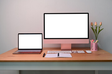 Modern workplace with computer, laptop and supplies on wooden desk.