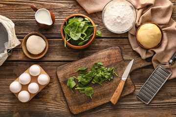 Ingredients for preparing spinach tart on wooden background