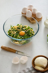 Ingredients for preparing spinach tart on light background