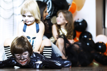 Fototapeta na wymiar happy family with childrens in costumes and makeup on a celebration of Halloween