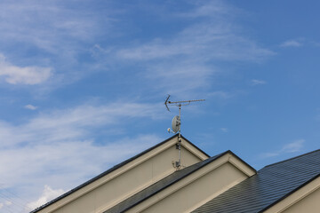 Fototapeta na wymiar 一戸建ての家の屋根に設置されたテレビ用受信アンテナ