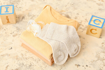 Set of baby clothes and accessories on grunge background
