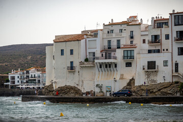 Casas blancas y mar azul en el puerto de Cadaqués con la iglesia y la playa, Costa Brava, España