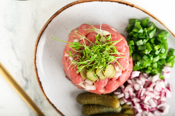 Plate with tasty beef tartare on light background, closeup