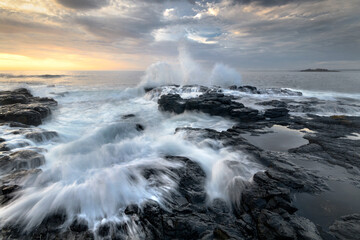 waves crashing on the rocks at the beach