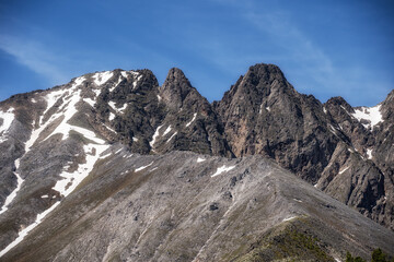 Wonderful mountains of Switzerland. Snow lies at the top of the ridge. Wildlife of incredible beauty. Rocks against the blue sky