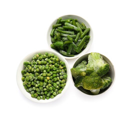 Bowls with frozen green vegetables on white background