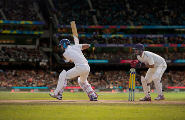Cricketer batsman ready to hit a shot during a match on the pitch - obrazy, fototapety, plakaty