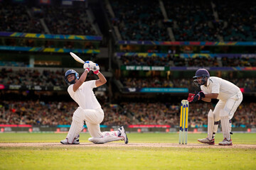 Cricketer batsman hitting a shot during a match on the cricket pitch during a match - obrazy, fototapety, plakaty
