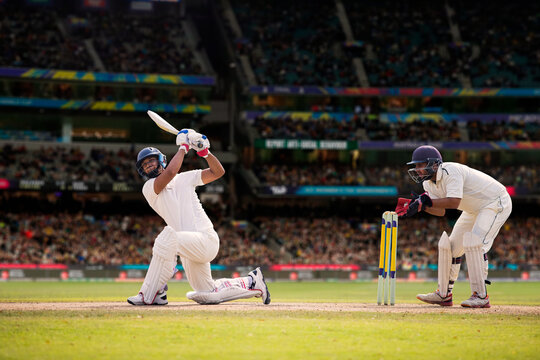 Cricketer batsman hitting a shot during a match on the cricket pitch during a match