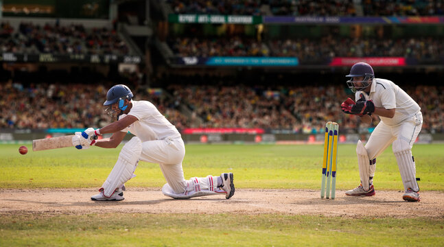 Cricketer batsman hitting a shot during a match on the pitch