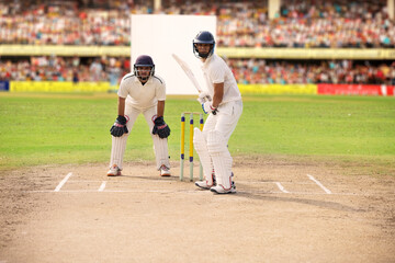 Cricketer batsman ready to hit a shot during a match on the crease