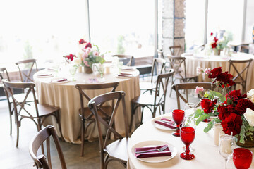 Wedding decor in a restaurant with red glasses and purple flowers