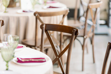Festive rustic wooden chairs. Cross in the back of the chair