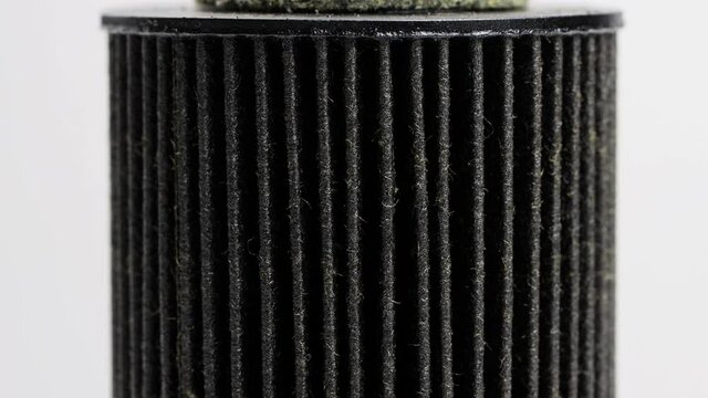 Car oil filter insert on white background. The concept of cleaning oil from dirt and impurities, macro