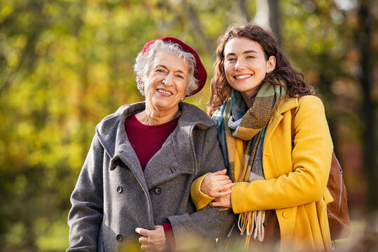 Old woman in park with daughter looking at camera
