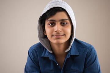 PORTRAIT OF A TEENAGE BOY WEARING JACKET AND LOOKING AT CAMERA