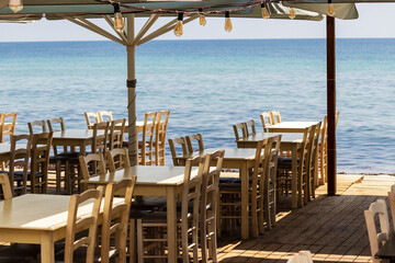 Chairs and tables of restaurants on the beach overlooking the open sea