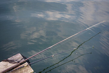 Rods lying on a wooden platform on the lake 