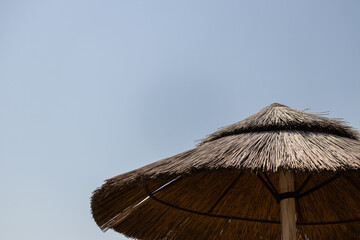 Reed umbrella during a sunny day with a blue sky in the background 