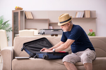 Old man preparing for trip at home